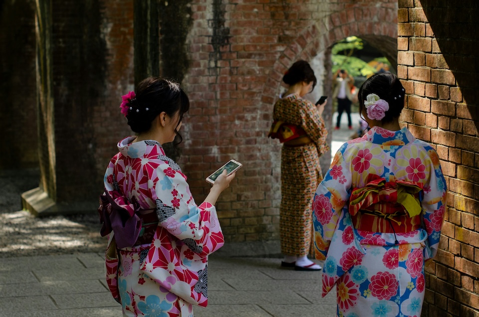 Mujeres en yukata usando el móvil